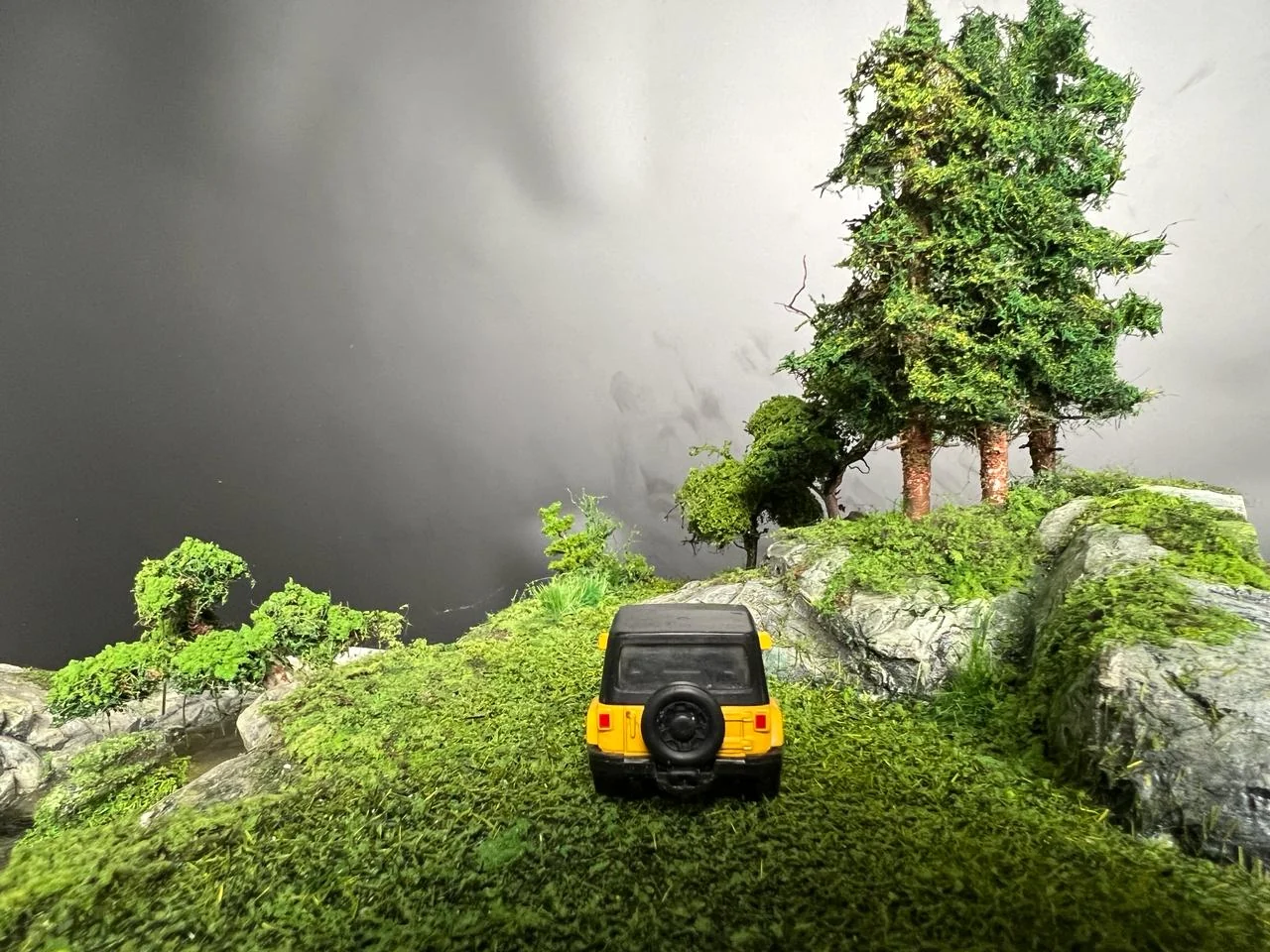 Miniature vehicle entering a forested rocky landscape.