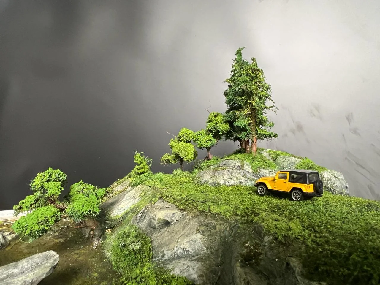 Miniature vehicle on a detailed countryside terrain diorama.