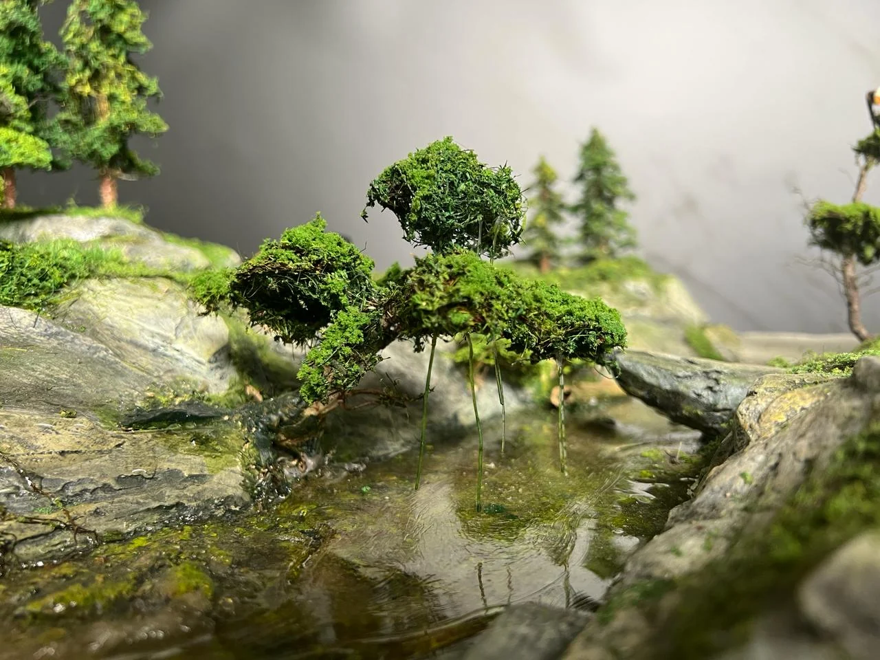Water and miniature terrain with detailed trees and rocks.