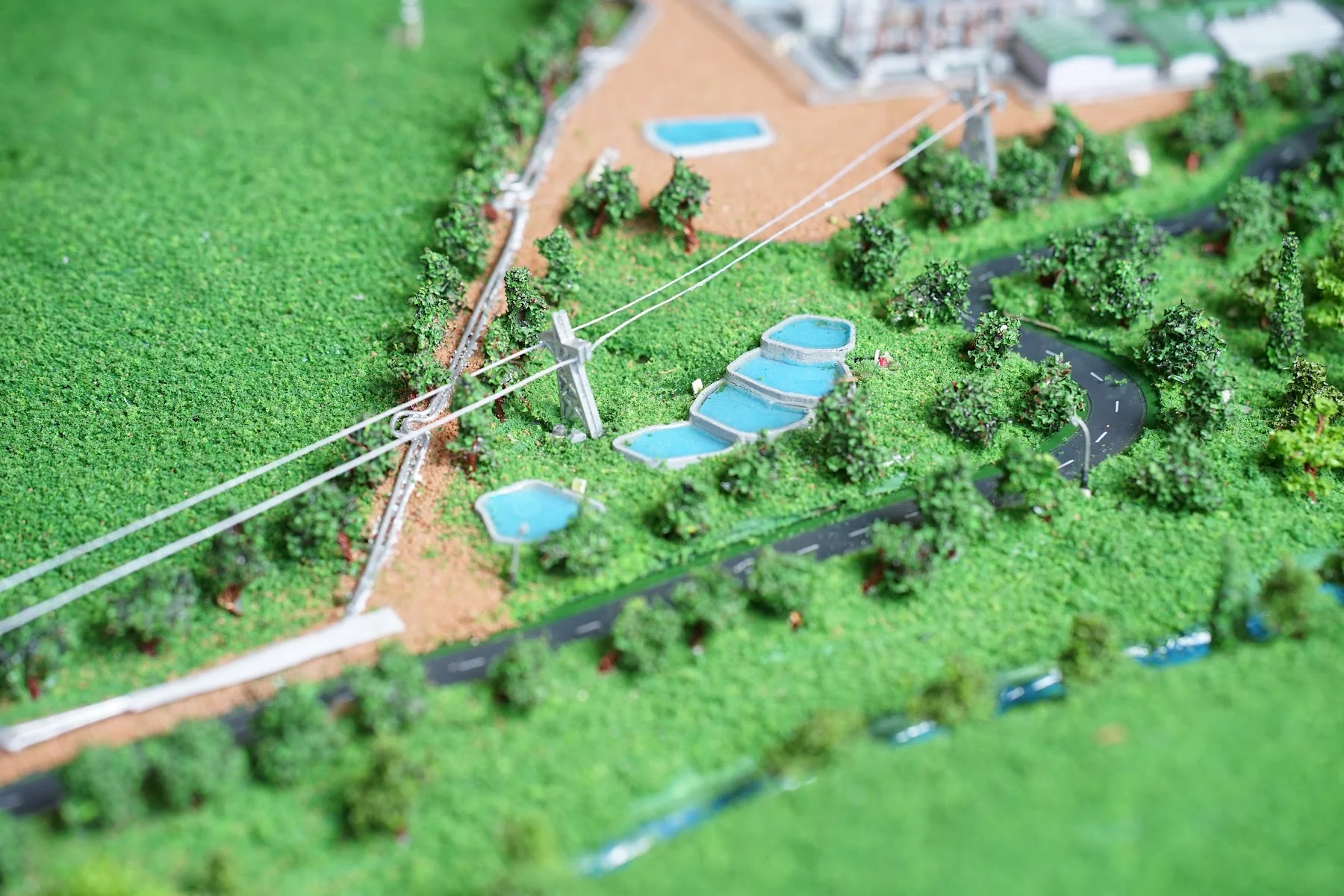 Aerial close-up of Muara Laboh power plant facility and road network in diorama.